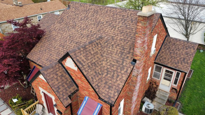 After roof replacement: Atlas Pinnacle Pristine shingles in Heatherblend on a brick home with black gutters.